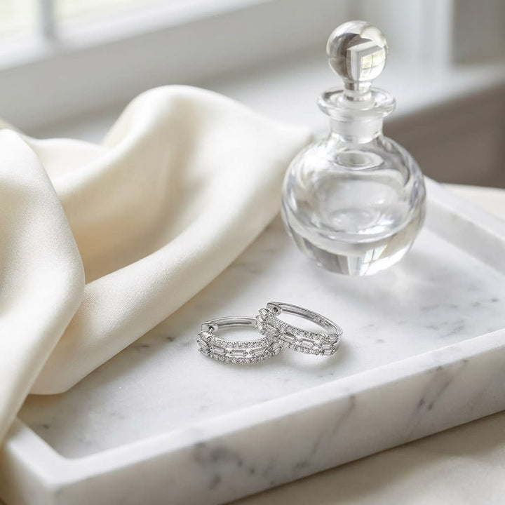 Diamond Baguette And Round Brilliant Multi-row Oval Hinged Hoop Earring in 14K White Gold, on marble vanity tray with silk