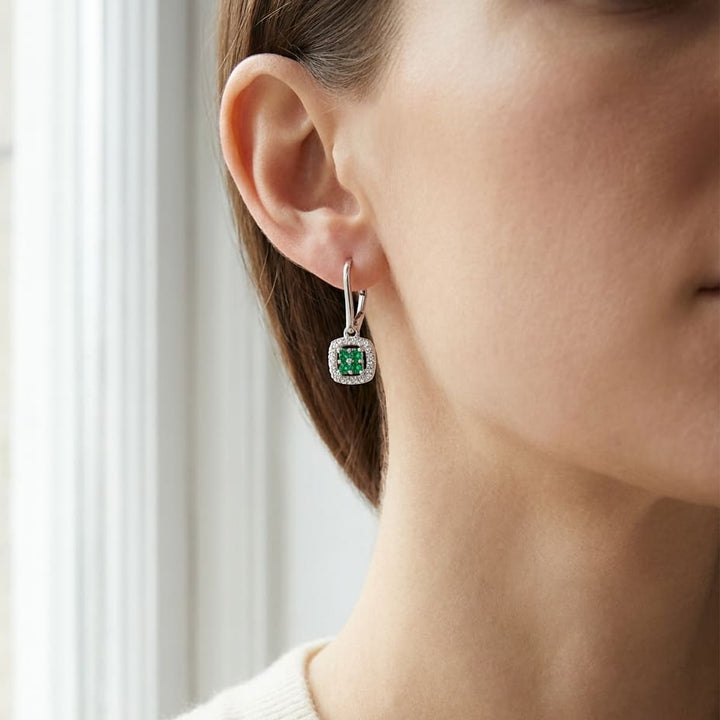 Created Emerald And Diamond Dangle Clover Leverback Earrings in 14K White Gold, worn close-up portrait