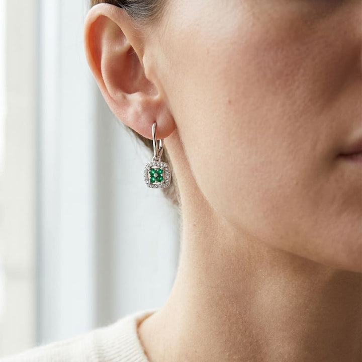 Created Emerald And Diamond Dangle Clover Leverback Earrings in 14K White Gold, worn close-up portrait