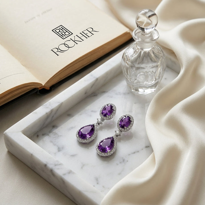Amethyst And Diamond Pave Dangle Earrings in 14K White Gold, on marble vanity tray with silk