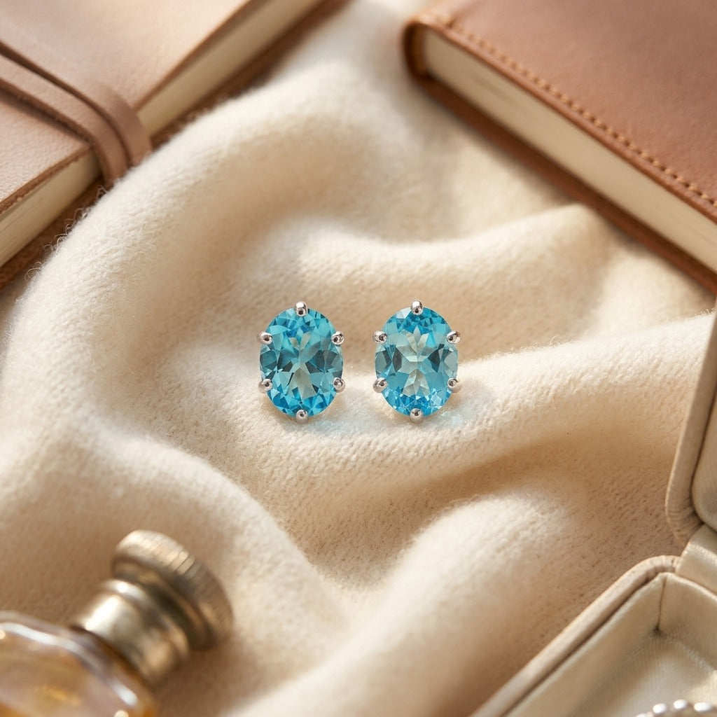 Blue Topaz Oval Stud Earrings in 14K White Gold - flat lay