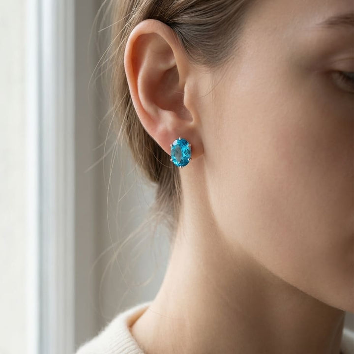 Swiss Blue Topaz Oval Stud Earrings in 14K White Gold, worn close-up portrait