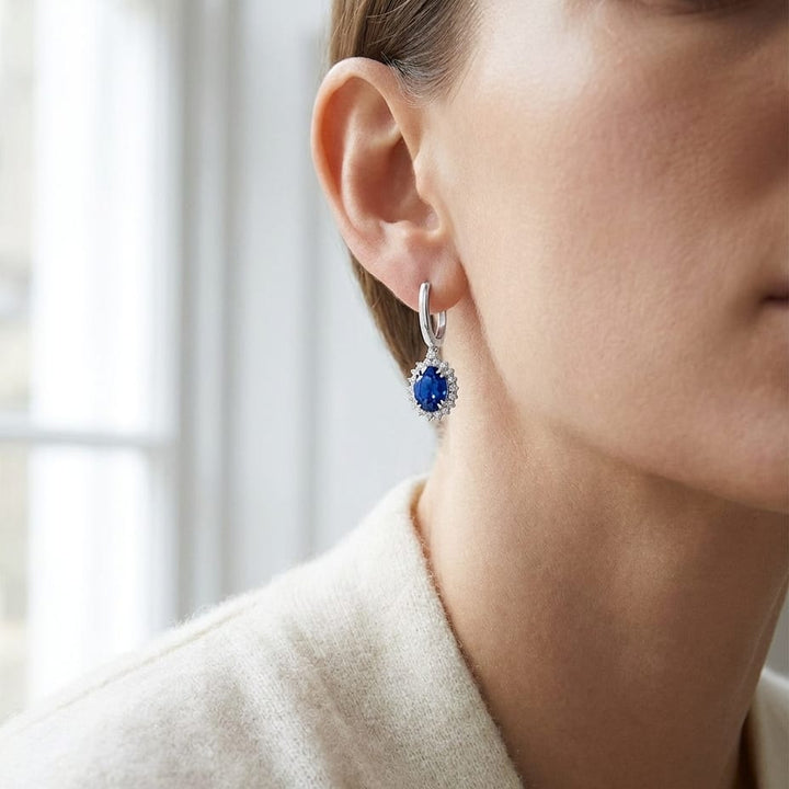 Sapphire Oval And Diamond Starburst Frame Earrings in 14K White Gold, worn close-up portrait