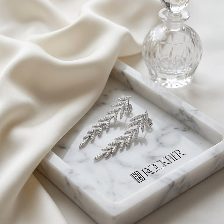 Diamond Pave Laurel Leaves Dangling Earrings in 14K White Gold, on marble vanity tray with silk