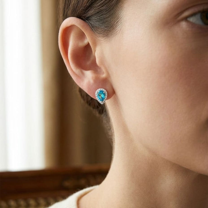Swiss Blue Topaz Round Brilliant Stud Earrings in 14K White Gold, worn close-up portrait