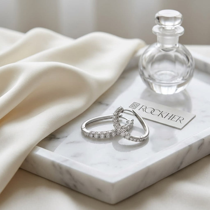 Diamond Pave Single Row Outside Oval Hoop Earrings in 14K White Gold, on marble vanity tray with silk