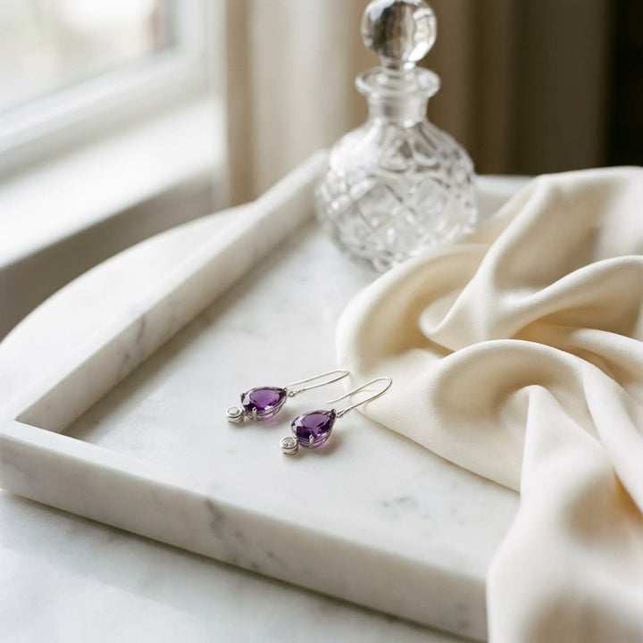 Amethyst and Bezel Diamond Teardrop Leverback Earrings in 14k White Gold 0.12ctw, on marble vanity tray with silk