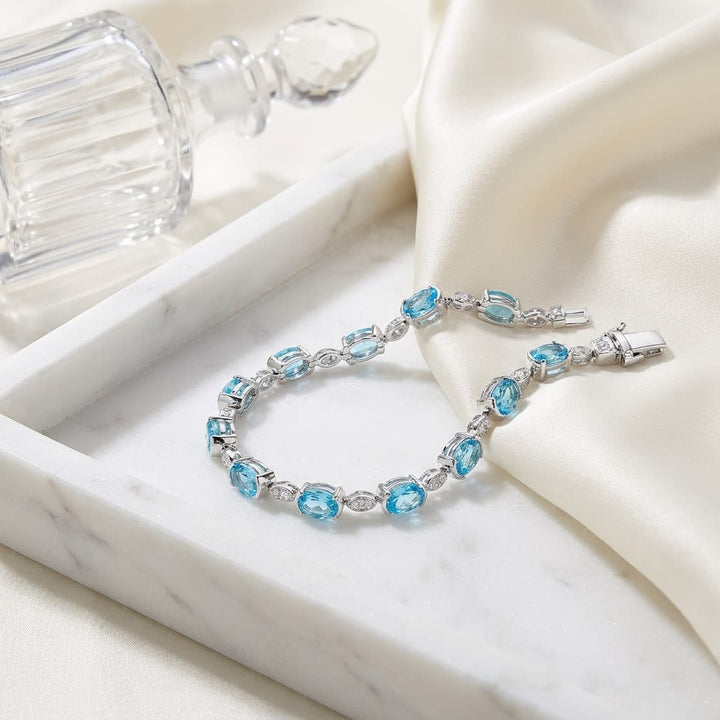 Blue Topaz Oval Half-bezel And Diamond Pave East-west Bracelet in 14K White Gold, on marble vanity tray with silk