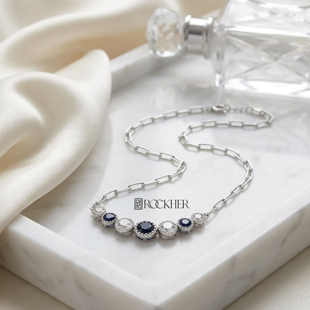 Sapphire And Diamond Graduated 7-stone Necklace With Millgrained Edging in 14K White Gold, on marble vanity tray with silk