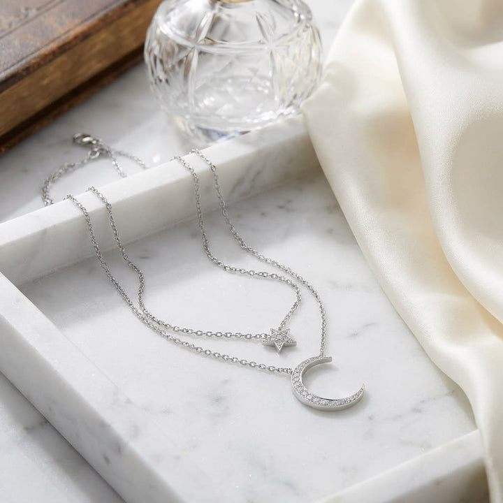 Diamond Star And Moon Layered Necklace in 14K White Gold, 16-18 Inch Adj Chain, on marble vanity tray with silk