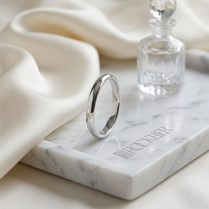 2mm Slightly Domed Traditional Oval Wedding Band in 14K White Gold, on marble vanity tray with silk
