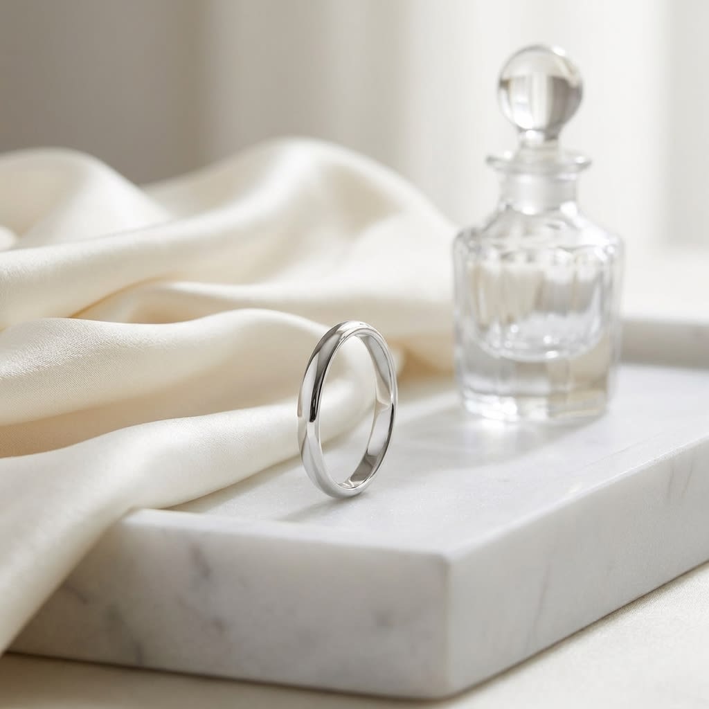2.5mm Slightly Domed Traditional Oval Wedding Band in 14K White Gold, on marble vanity tray with silk
