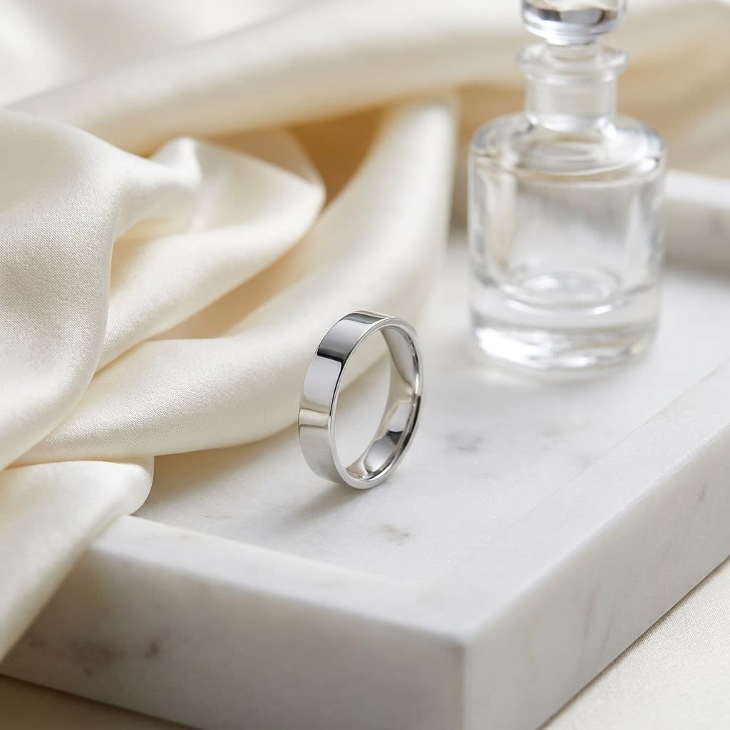 4mm Flat Comfort-Fit Wedding Band in 14K White Gold, on marble vanity tray with silk