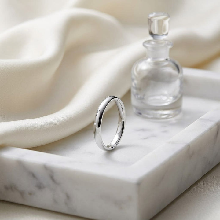 2.5mm Slightly Domed Comfort-Fit Wedding Band in 14K White Gold, on marble vanity tray with silk
