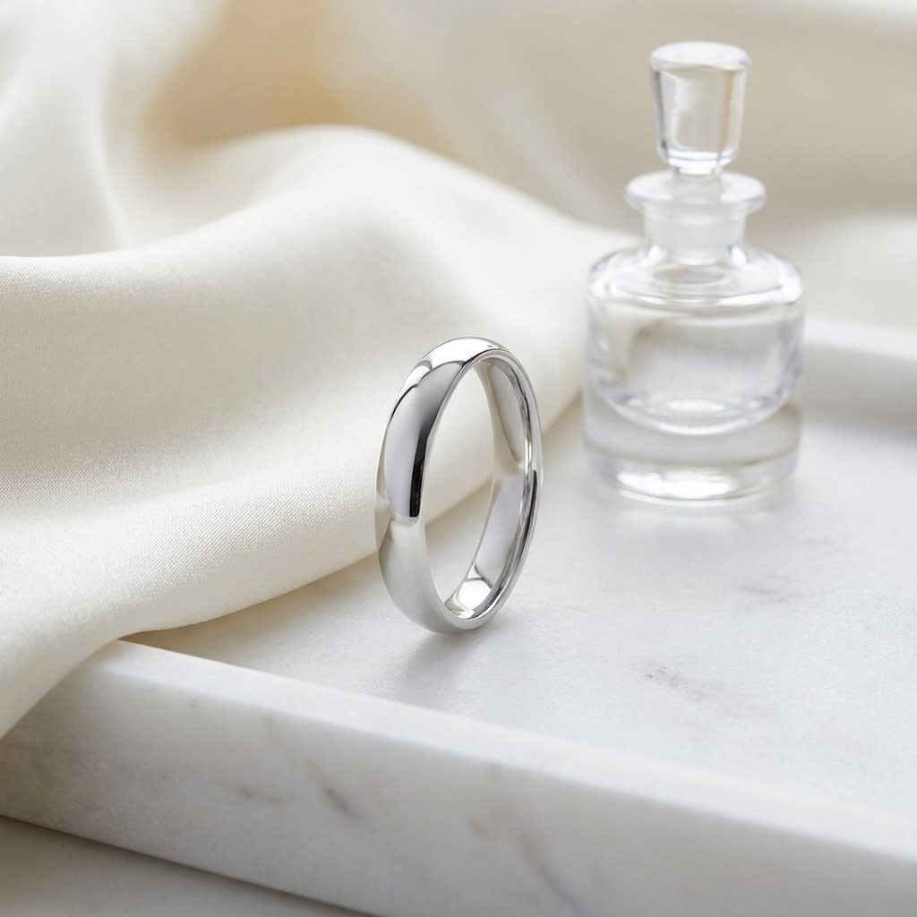 4mm Slightly Domed Comfort-Fit Wedding Band in 14K White Gold, on marble vanity tray with silk