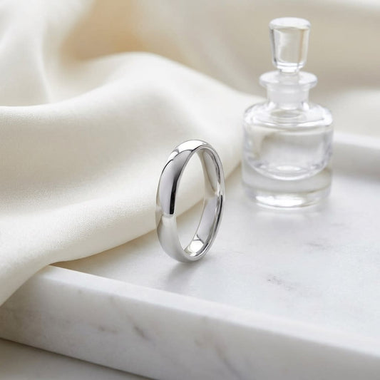 4mm Slightly Domed Comfort-Fit Wedding Band in 14K White Gold, on marble vanity tray with silk