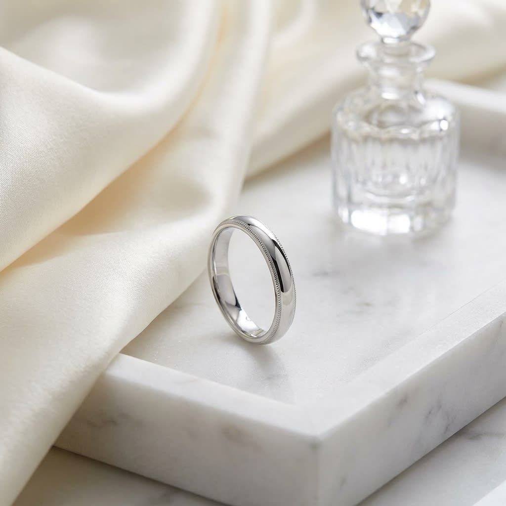 4mm Slightly Domed Milgrain Comfort-Fit Wedding Band in 14K White Gold, on marble vanity tray with silk