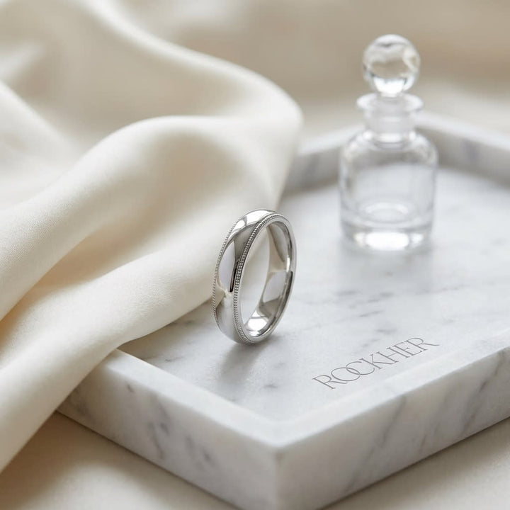 4mm Slightly Domed Super Light Milgrain Comfort-Fit Wedding Band in 14K White Gold, on marble vanity tray with silk