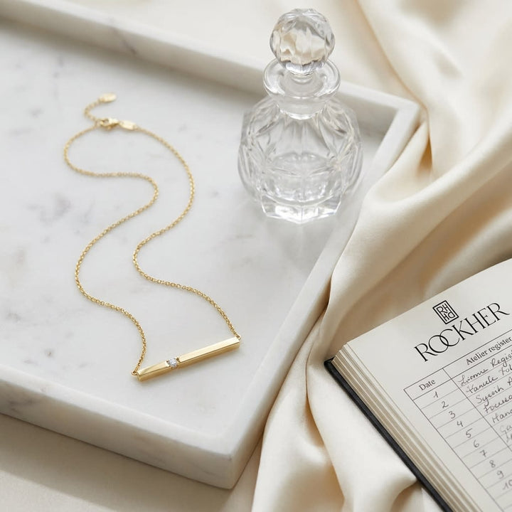 Diamond Bar Necklace in 14K Yellow Gold, on marble vanity tray with silk