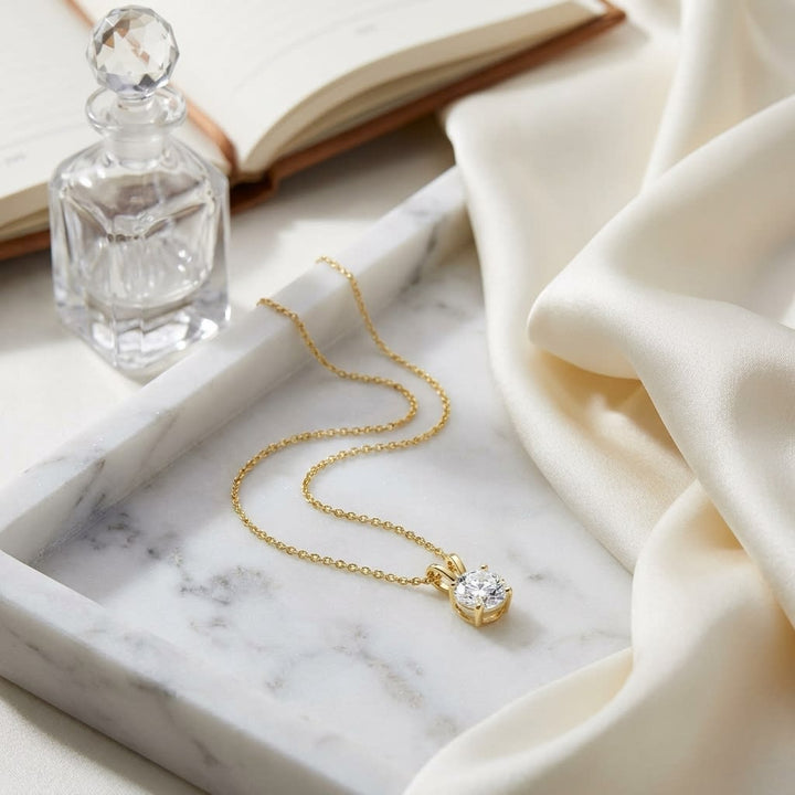 Natural Diamond Round Brilliant Solitaire Pendant in 14K Yellow Gold, 1 ct. t.w., on marble vanity tray with silk