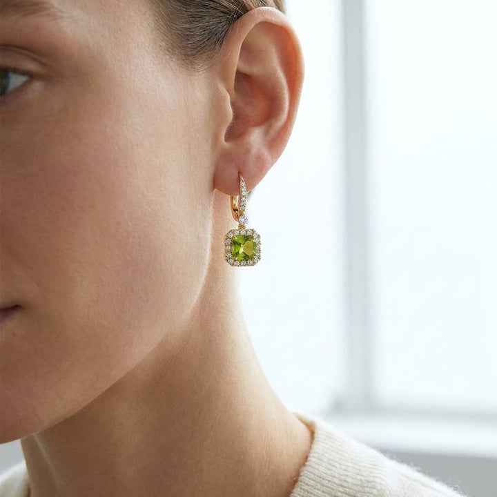 Peridot And Diamond Cushion Dangle Earrings With Pave Tops In 14k Yellow Gold (6mm), worn close-up portrait