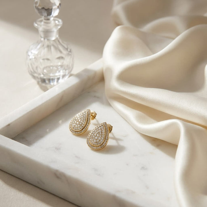 Diamond Teardrop Stud Earrings In 14k Yellow Gold 0.25ctw, on marble vanity tray with silk