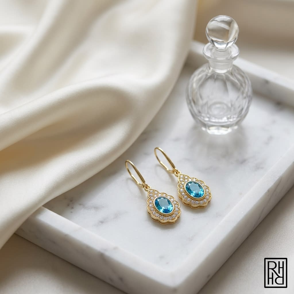 Blue Topaz And Diamond Oval Bezel Leverback Earrings With Teardrop Scallop Frame in 14K Yellow Gold, on marble vanity tray with silk