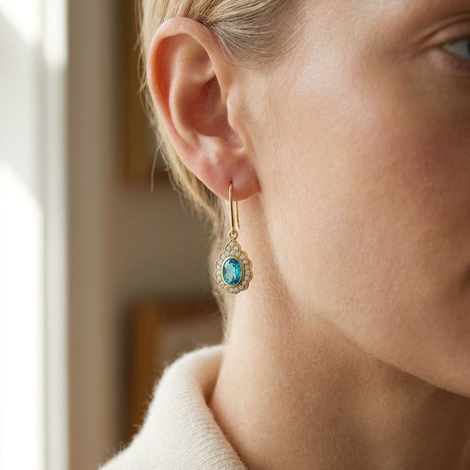 Blue Topaz And Diamond Oval Bezel Leverback Earrings With Teardrop Scallop Frame in 14K Yellow Gold, worn close-up portrait