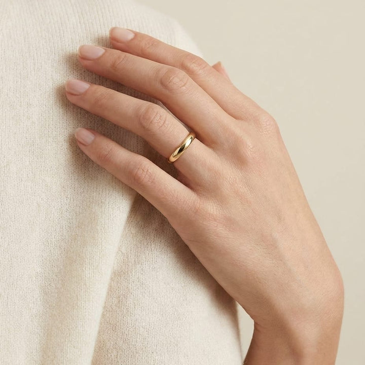 2mm Slightly Domed Traditional Oval Wedding Band in 14K Yellow Gold, worn on hand, full view