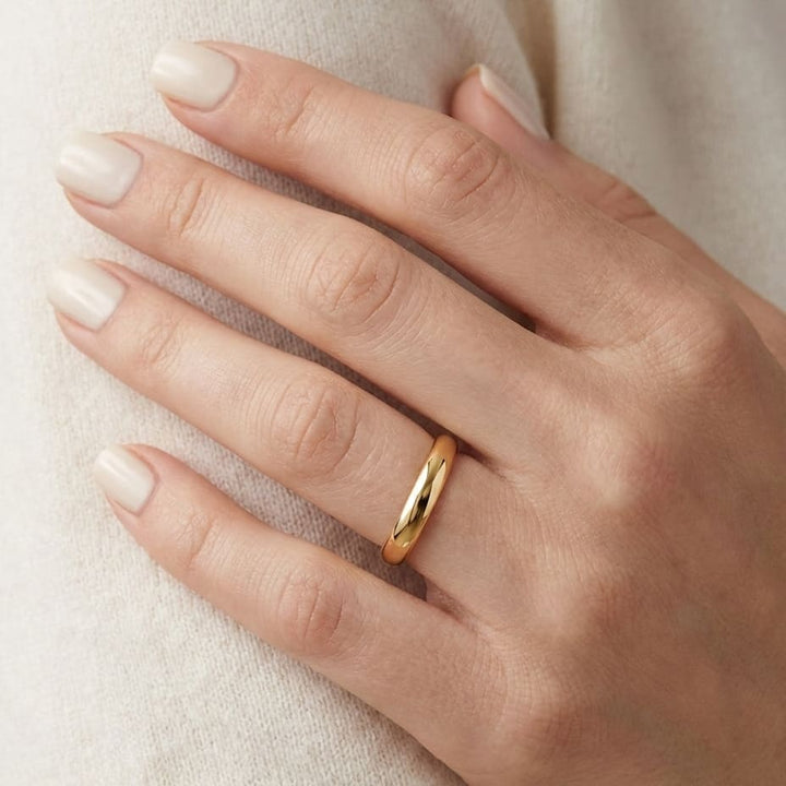 2.5mm Slightly Domed Traditional Oval Wedding Band in 14K Yellow Gold, worn on hand, close-up