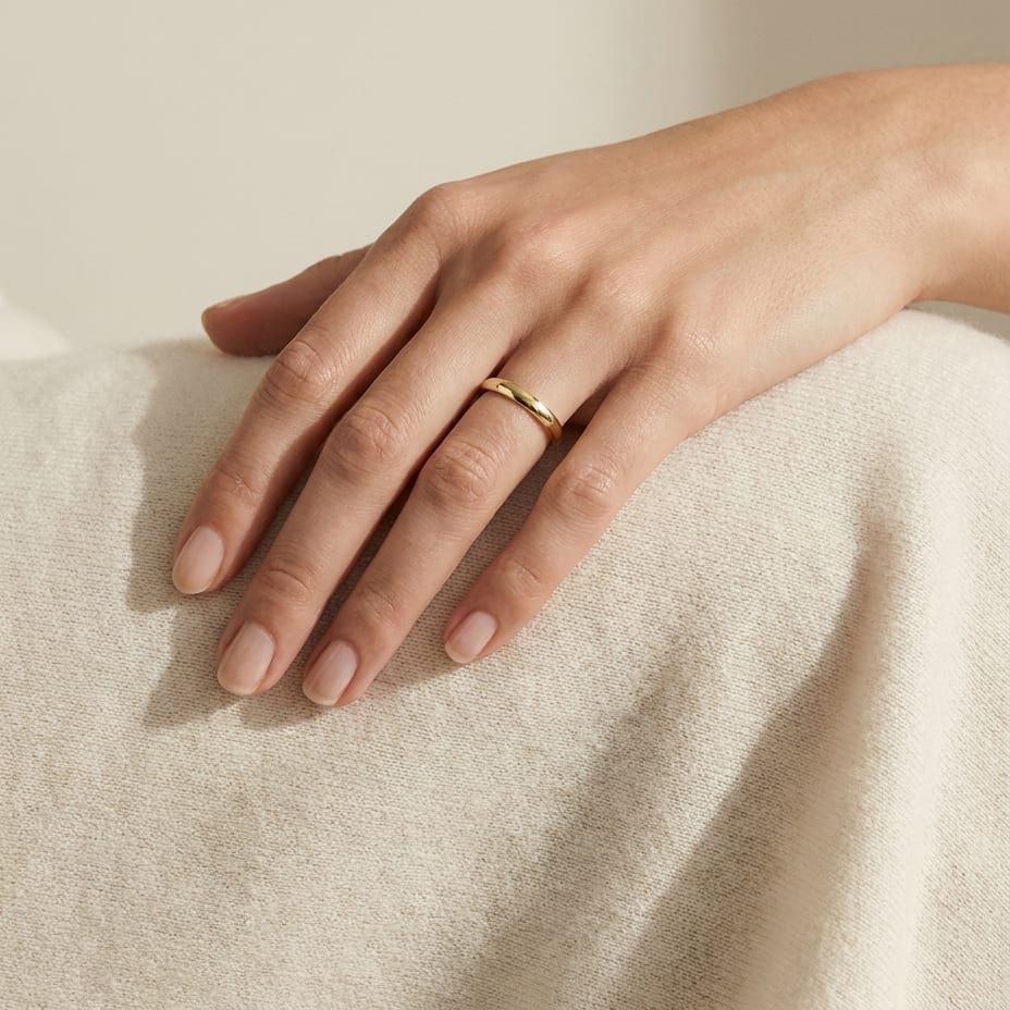 2.5mm Slightly Domed Traditional Oval Wedding Band in 14K Yellow Gold, worn on hand, full view