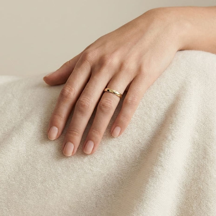 3mm Slightly Domed Traditional Oval Wedding Band in 14K Yellow Gold, worn on hand, full view