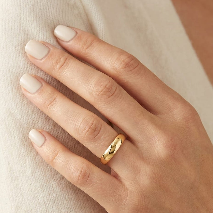4mm Slightly Domed Traditional Oval Wedding Band in 14K Yellow Gold, worn on hand, close-up