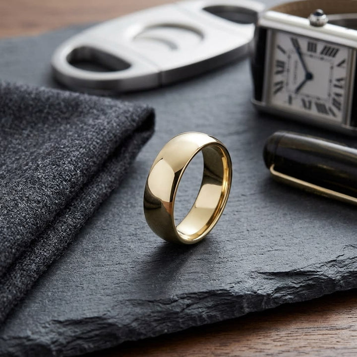 7mm Slightly Domed Traditional Oval Wedding Band in 14K Yellow Gold, on walnut surface with pocket square
