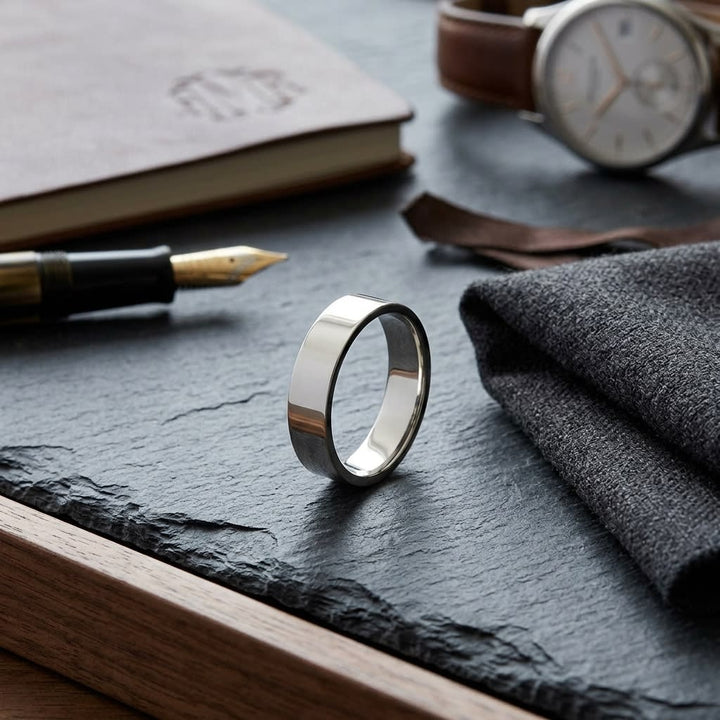5mm Traditional Flat Wedding Band in 14K Yellow Gold, on walnut surface with pocket square