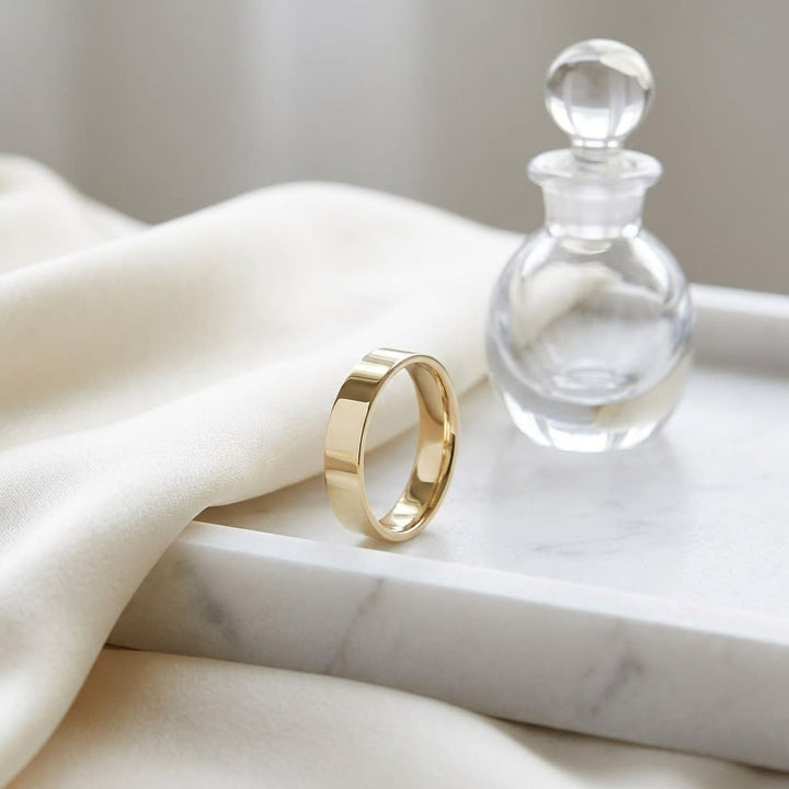 4mm Flat Comfort-Fit Wedding Band in 14K Yellow Gold, on marble vanity tray with silk