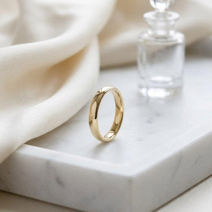 3.5mm Flat Comfort-Fit Wedding Band in 14K Yellow Gold, on marble vanity tray with silk