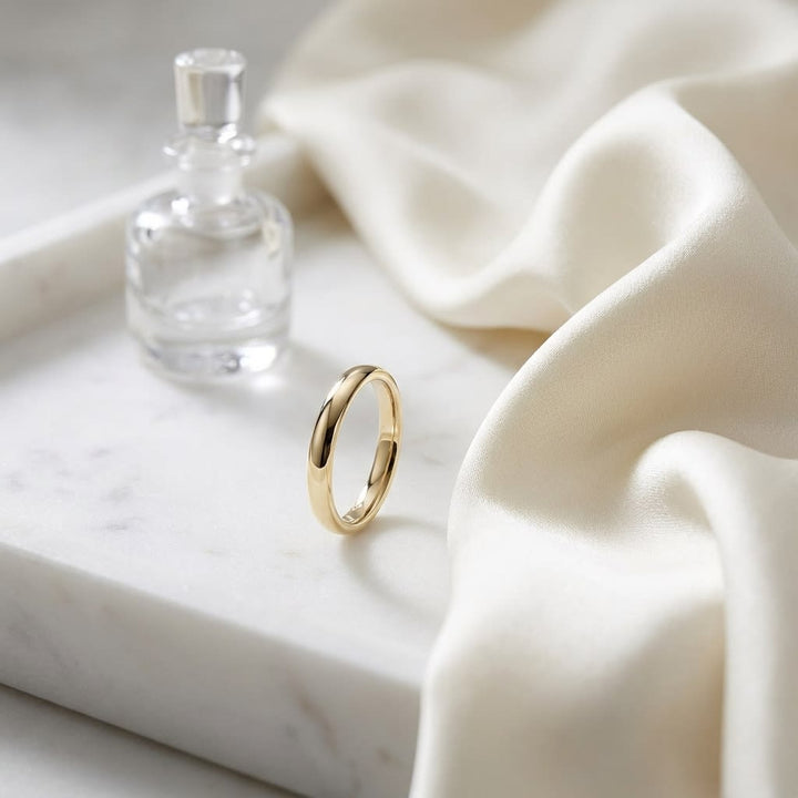 3mm High Dome Comfort-Fit Wedding Band in 14K Yellow Gold, on marble vanity tray with silk