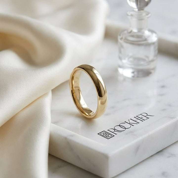 4mm High Dome Comfort-Fit Wedding Band in 14K Yellow Gold, on marble vanity tray with silk