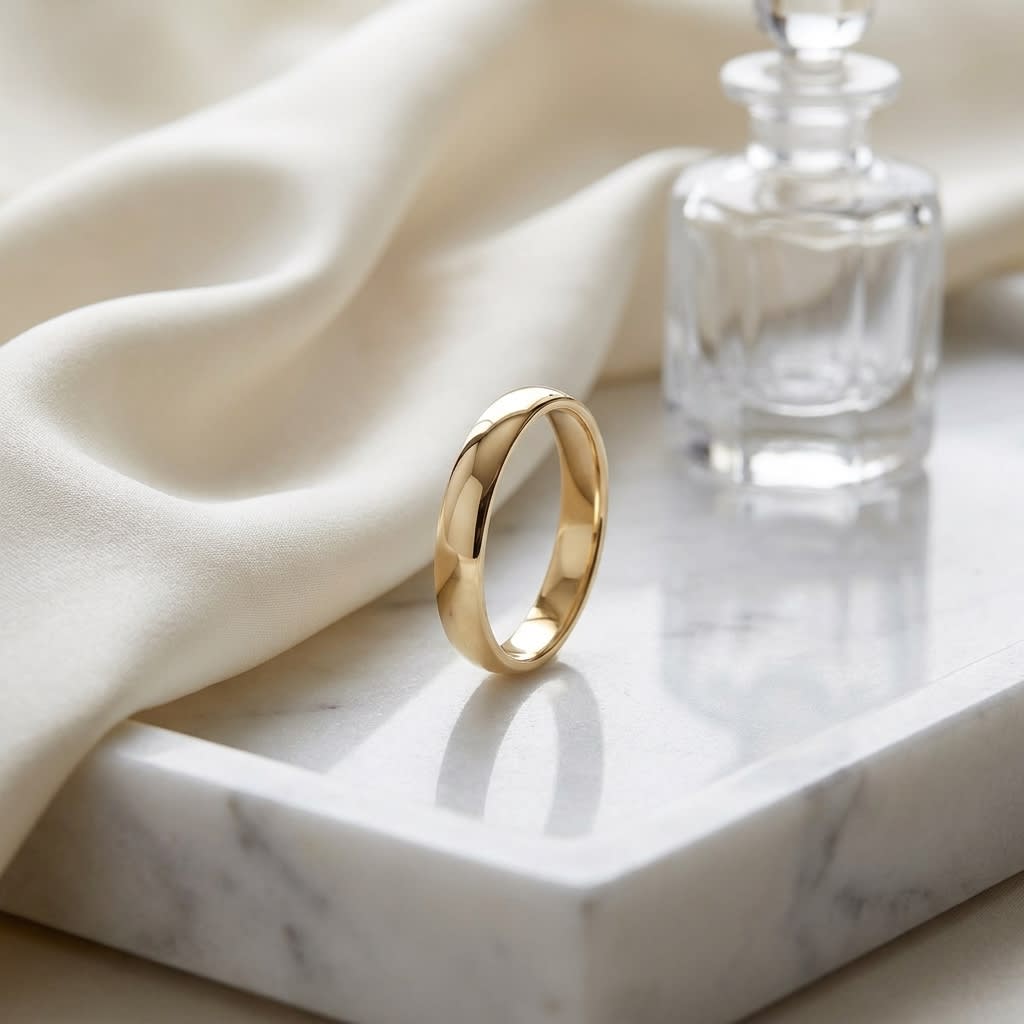 3mm Low Dome Wedding Band in 14K Yellow Gold, on marble vanity tray with silk
