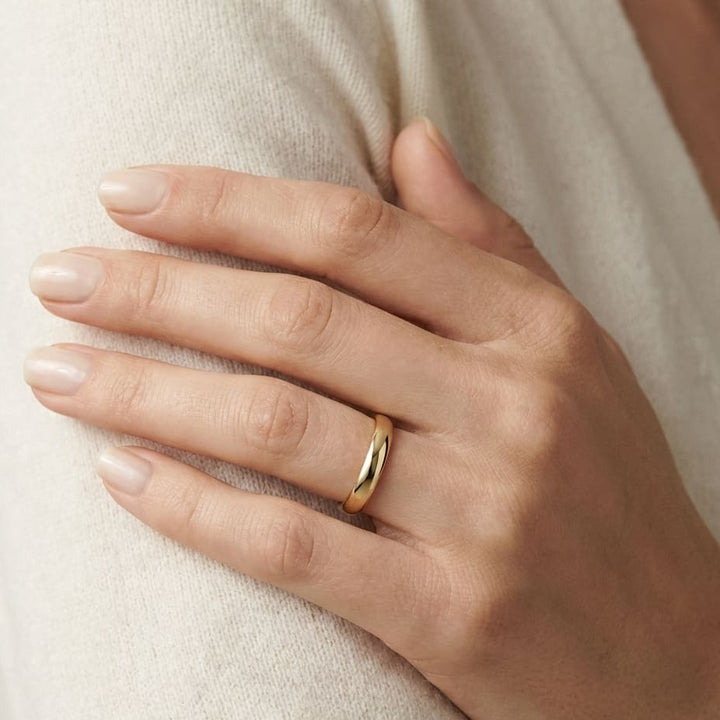 2.5mm Slightly Domed Comfort-Fit Wedding Band in 14K Yellow Gold, worn on hand, close-up