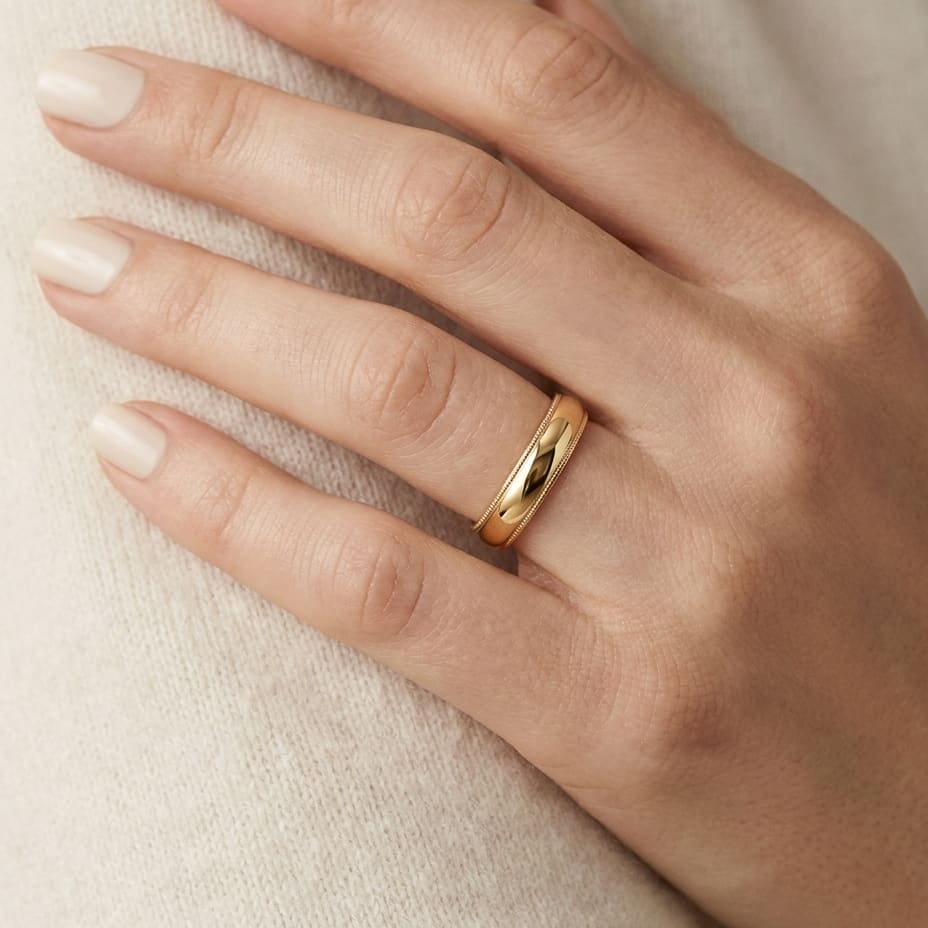 4mm Slightly Domed Milgrain Comfort-Fit Wedding Band in 14K Yellow Gold, worn on hand, close-up