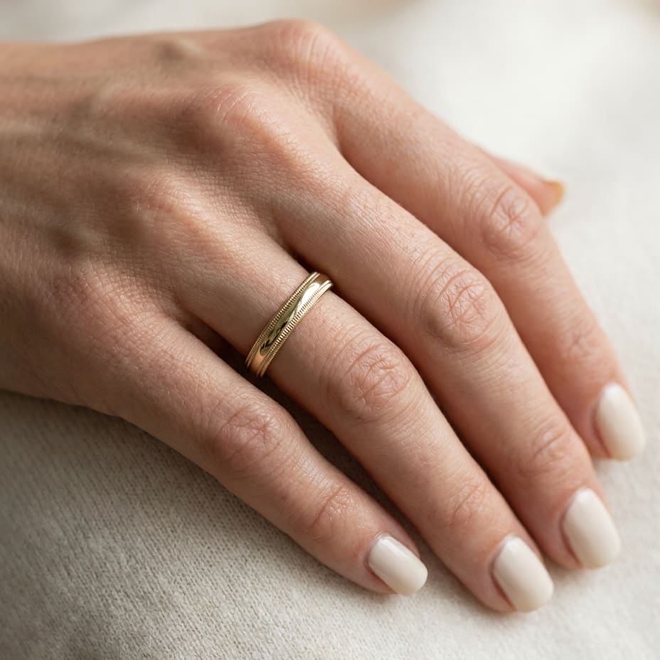4mm Slightly Domed Double Milgrain Comfort-Fit Wedding Band in 14K Yellow Gold, worn on hand, close-up