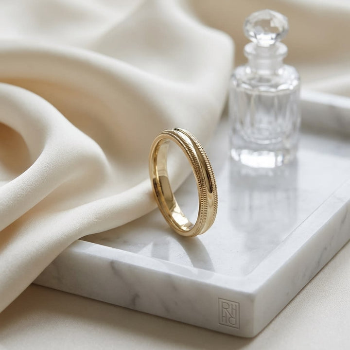 4mm Slightly Domed Double Milgrain Comfort-Fit Wedding Band in 14K Yellow Gold, on marble vanity tray with silk