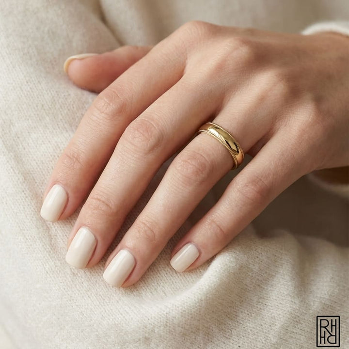 4mm Slightly Domed Super Light Milgrain Comfort-Fit Wedding Band in 14K Yellow Gold, worn on hand, close-up