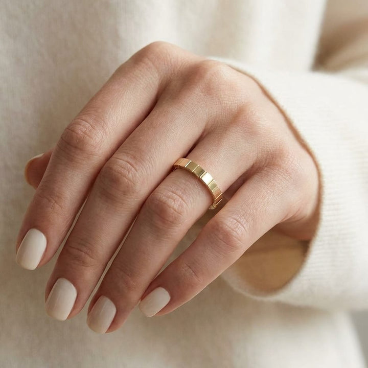 2mm High Polish Carved Wedding Band in 14K Yellow Gold, worn on hand, close-up