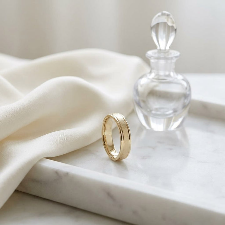 4mm Wired Finish High Polished Round Edge Carved Wedding Band in 14K Yellow Gold, on marble vanity tray with silk