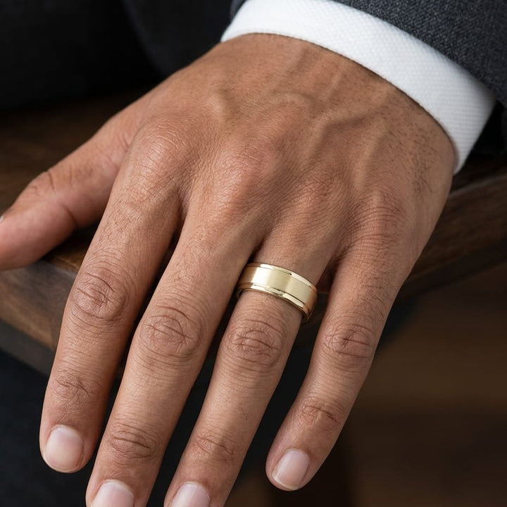 7mm Satin Finish Carved Wedding Band in 14K Yellow Gold, worn on hand, masculine close-up