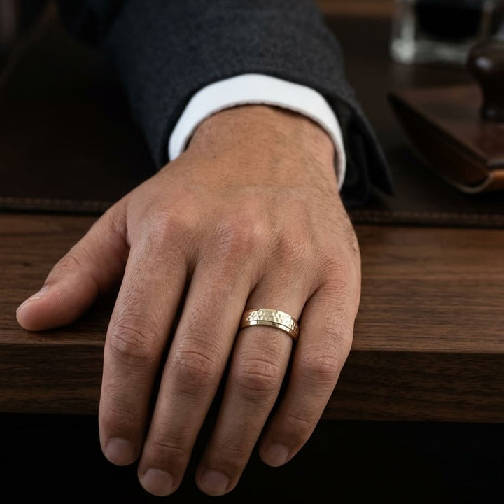 7.5mm Hammered Finish Beveled Edge Carved Wedding Band in 14K Yellow Gold, worn on hand, masculine full view