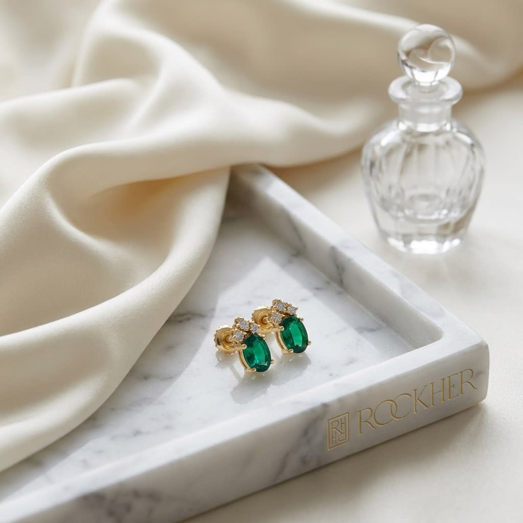 Created Emerald Round Brilliant Stud Earrings in 14K Yellow Gold, on marble vanity tray with silk